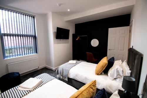 a hotel room with two beds and a tv at Winter Gardens Suites by Sasco in Blackpool