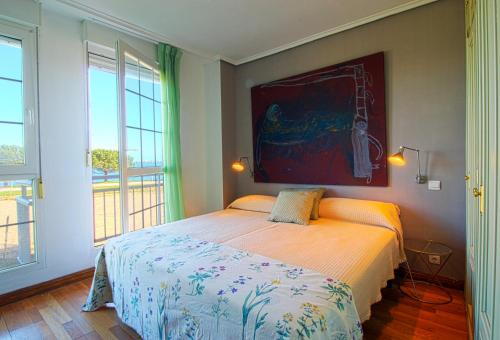 1 dormitorio con 1 cama y una pintura en la pared en El Rincón del Puerto en Santander