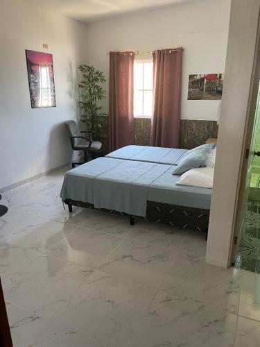 a bedroom with a bed and a chair and a window at Playa El Obipo C La Marea building La Libertad in La Libertad