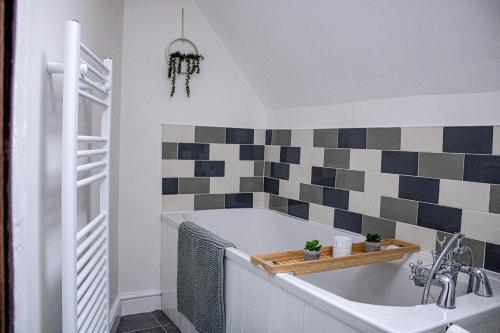 een badkamer met een bad en een wastafel bij Forget me not cottage in Ironbridge