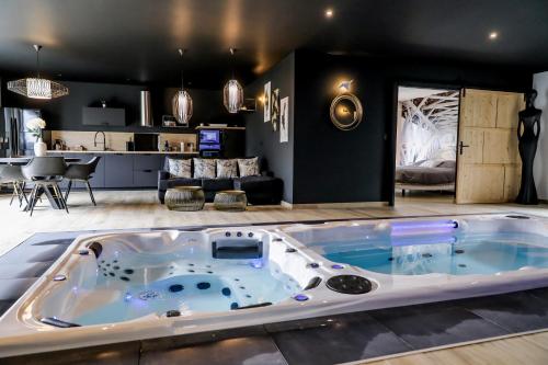 jacuzzi en el medio de una sala de estar en Au domaine des anges Gites avec Jacuzzi privatif dans la chambre, en Bain-de-Bretagne