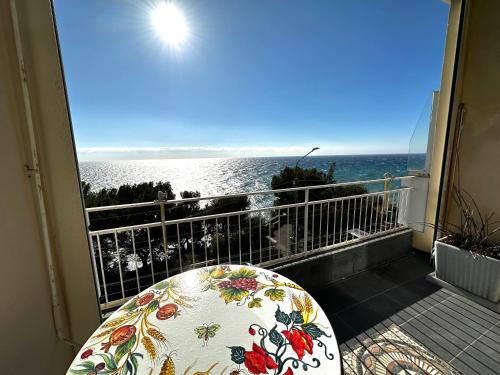 een balkon met een zitje en uitzicht op de oceaan bij Suite Fronte Mare - Sanremo in Sanremo