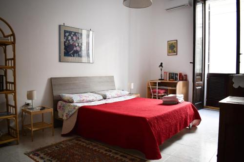 a bedroom with a bed with a red blanket at La Terrazza sul Tempio in Brindisi