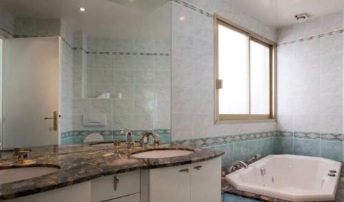une salle de bain avec deux lavabos et une baignoire dans l'établissement Superbe Appartement vue mer Pointe Croisette, à Cannes