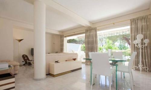 un salon avec une table et des chaises blanches dans l'établissement Superbe Appartement vue mer Pointe Croisette, à Cannes