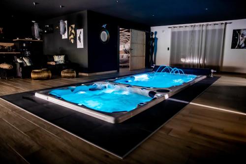a large jacuzzi tub in the middle of a room at Au domaine des anges, 3 gîtes luxueux avec Jacuzzi privatif, sauna, mini-piscine, piscine extérieure chauffée en saison in Bain-de-Bretagne