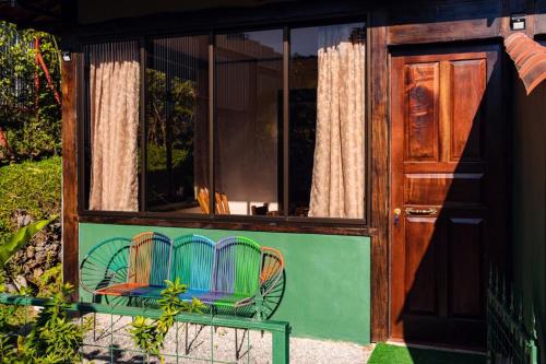 a house with a window with chairs in it at FLOR DE PARAISO BUNGALOWS in Montezuma