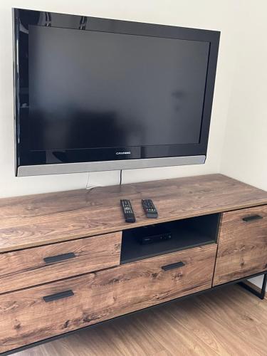a flat screen tv sitting on top of a wooden entertainment center at Ferienwohnungen Fritze Bürger in Schiefling am See