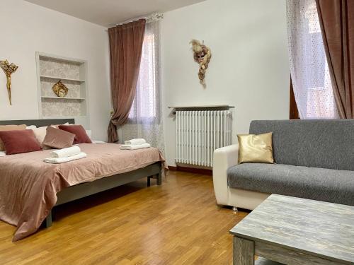 La Dogaressa Guest House في البندقية: غرفة معيشة مع سرير وأريكة