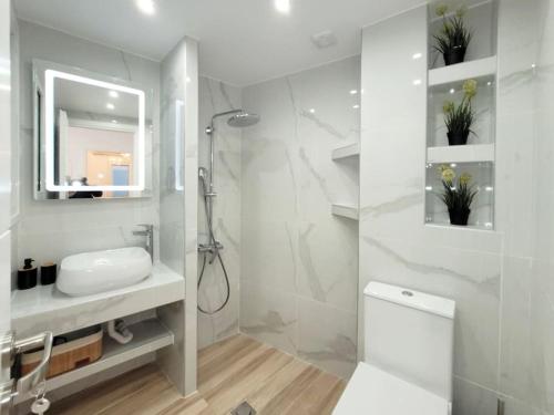 y baño blanco con lavabo y ducha. en Acropolis Thisio Apartment 2 bedrooms 2 bathrooms, en Atenas