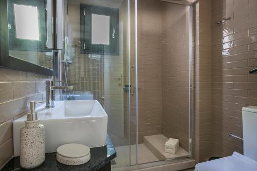 a bathroom with a shower and a sink and a toilet at Melina Apartments Sea View in Argostoli
