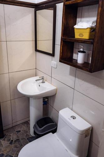 a small bathroom with a toilet and a sink at FLOR DE PARAISO BUNGALOWS in Montezuma