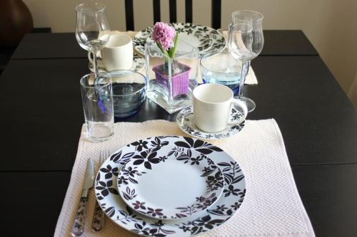 a table with a black and white plate and glasses at APARTMENT - Berlin City Studio in Berlin