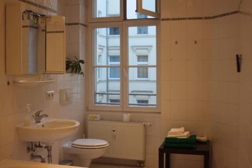 a bathroom with a sink and a toilet and a window at APARTMENT - Berlin City Studio in Berlin
