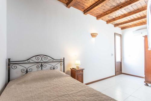 Un dormitorio con una cama en una habitación blanca. en MariGiò Rooms, en Alliste