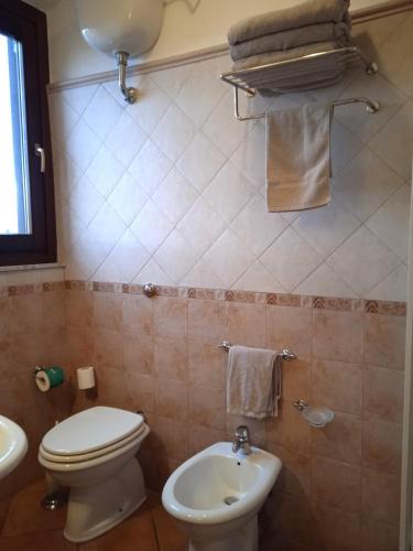 a bathroom with a toilet and a sink at Hotel Moderno in SantʼAntìoco