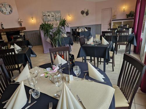 a dining room with blue tables and chairs with flowers at Le Gue de Genes in Ambrieres Les Vallees
