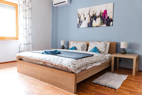 a bedroom with a bed with blue walls at Tulipános Ház in Badacsonytomaj
