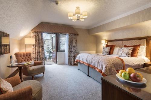 una camera d'albergo con letto e tavolo con cesto di frutta di Armathwaite Hall Hotel & Spa a Bassenthwaite