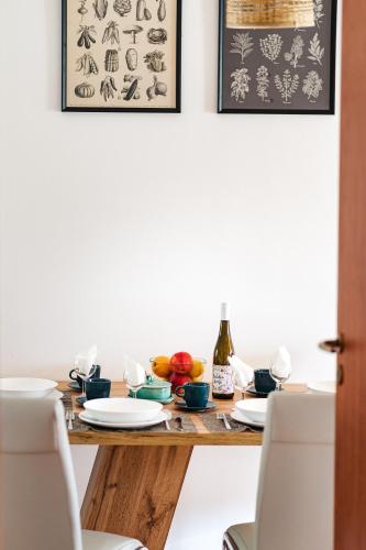 a dining room table with plates and a bottle of wine at Tulipános Ház in Badacsonytomaj