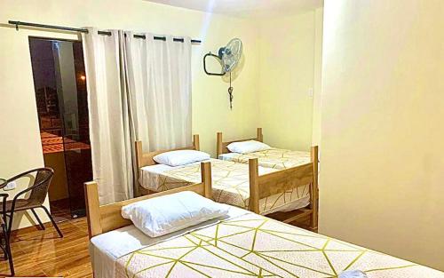 a room with three beds and a fan at Hospedaje La Posada del Chino in Los Órganos