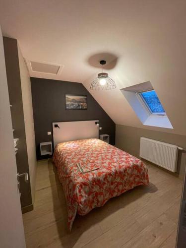 um quarto com uma cama e um tecto com uma janela em Joli gîte au cœur du Cézallier 3étoiles em Landeyrat