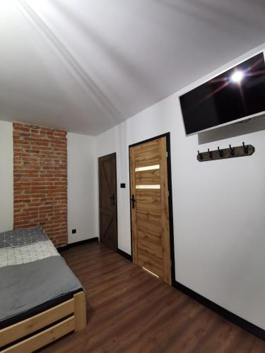 a bedroom with a bed and a brick wall at Stalowy Gościniec in Stalowa Wola