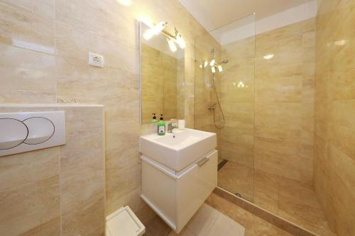 a bathroom with a toilet and a sink and a shower at Apartments Punta in Privlaka