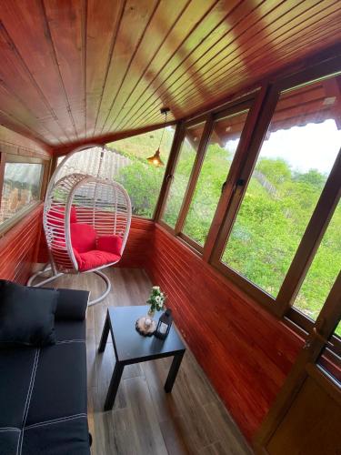 a living room with a swing and a table at Mountain escape in Carpathian in Malaia