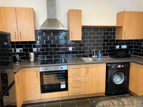 una cucina con lavandino e lavastoviglie di 2 bedroom city centre apartment 35 Victoria street a Liverpool