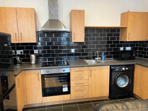 a kitchen with a sink and a dishwasher at 2 bedroom city centre apartment 35 Victoria street in Liverpool