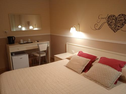 a bedroom with a bed with red and white pillows at Hotel Moderno in SantʼAntìoco