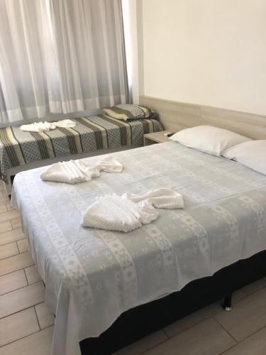 two beds in a hotel room with towels on them at Condomínio Polinésia in Porto De Galinhas