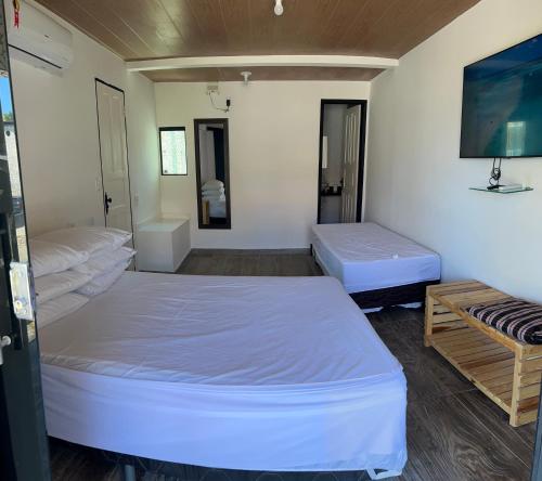 a room with two beds and a tv in it at Village Galés de Maragogi in Maragogi