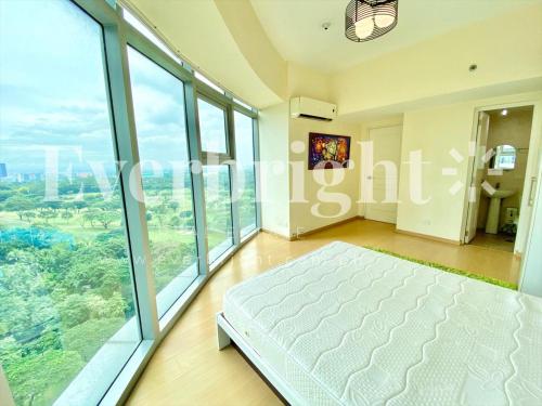 - une chambre avec un grand lit et de grandes fenêtres dans l'établissement A place that promotes calmness and tranquility., à Manille