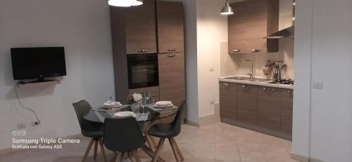 a kitchen with a table and chairs and a television at CIVICO 16A - Apartment - with private parking in Quartu SantʼElena