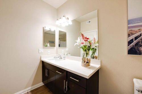 uma casa de banho com um lavatório e um vaso de flores em The Nest a Spacious 1 Bedroom Apartment em Los Angeles