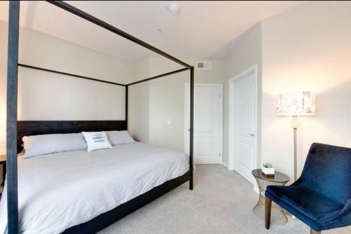 um quarto com uma cama de dossel preta e uma cadeira azul em The Nest a Spacious 1 Bedroom Apartment em Los Angeles