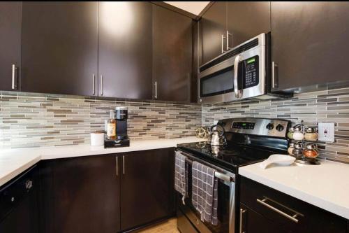 a kitchen with a stove and a microwave at The Nest a Spacious 1 Bedroom Apartment with a Pool View in Los Angeles