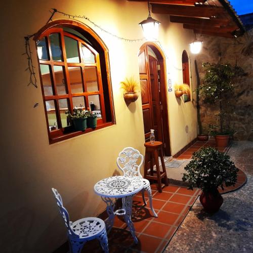 a patio with two chairs and a table and a window at El Molino Hostal in El Carmen