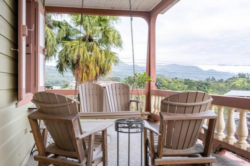a porch with chairs and a table and a view of the ocean at Cabin mountain view near Ponce slepts 8 in Ponce