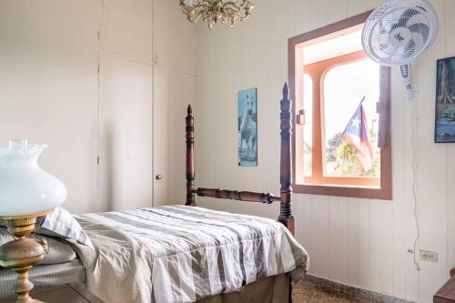 a bedroom with a bed and a window at Cabin mountain view near Ponce slepts 8 in Ponce