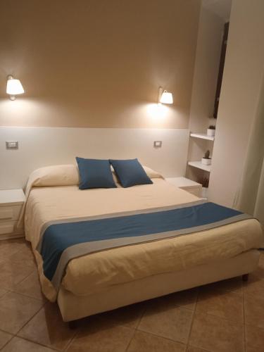 a bedroom with a large bed with blue pillows at Hotel Moderno in SantʼAntìoco