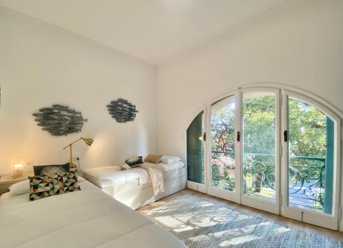 1 dormitorio con cama y ventana grande en CasaViva-Stylish Trilo with AC-shared pool-parking, en Génova
