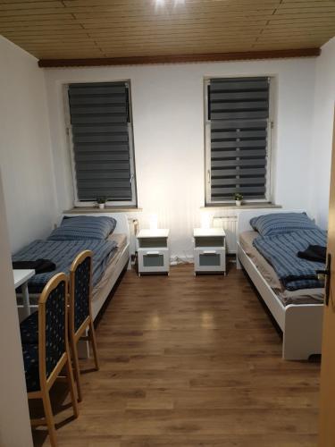 twee bedden in een kamer met twee ramen bij FeWo Nina 2 - Monteurwohnung in Weißenfels
