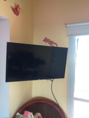 a flat screen tv hanging on a wall at Mi lugar in Villa Carlos Paz