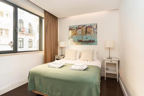 リスボンにあるComfortable Apartment in Marquês de Pombalのベッドルーム1室(ベッド1台、タオル2枚付)