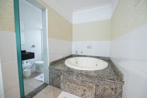 a bathroom with a bath tub and a toilet at Expo Hotel in Sao Paulo