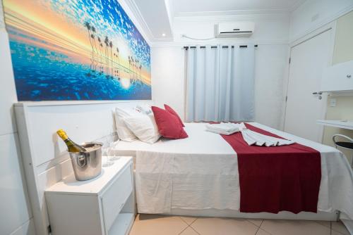 a white bedroom with a bed and a painting on the wall at Expo Hotel in Sao Paulo