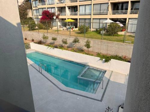 an overhead view of a swimming pool in front of a building at Hermoso y acogedor departamento a pasos del mar - Ideal Parejas, Teletrabajo in Concón